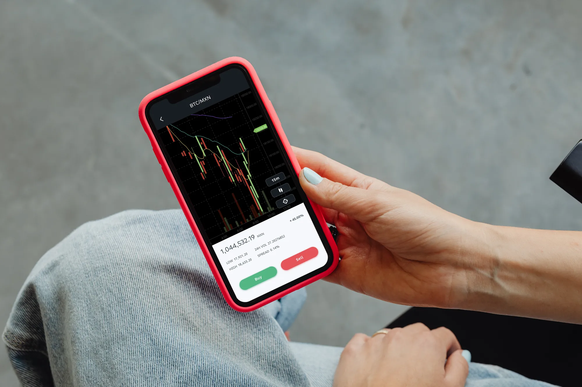 Bitso trading chart on a phone held in someone's lap